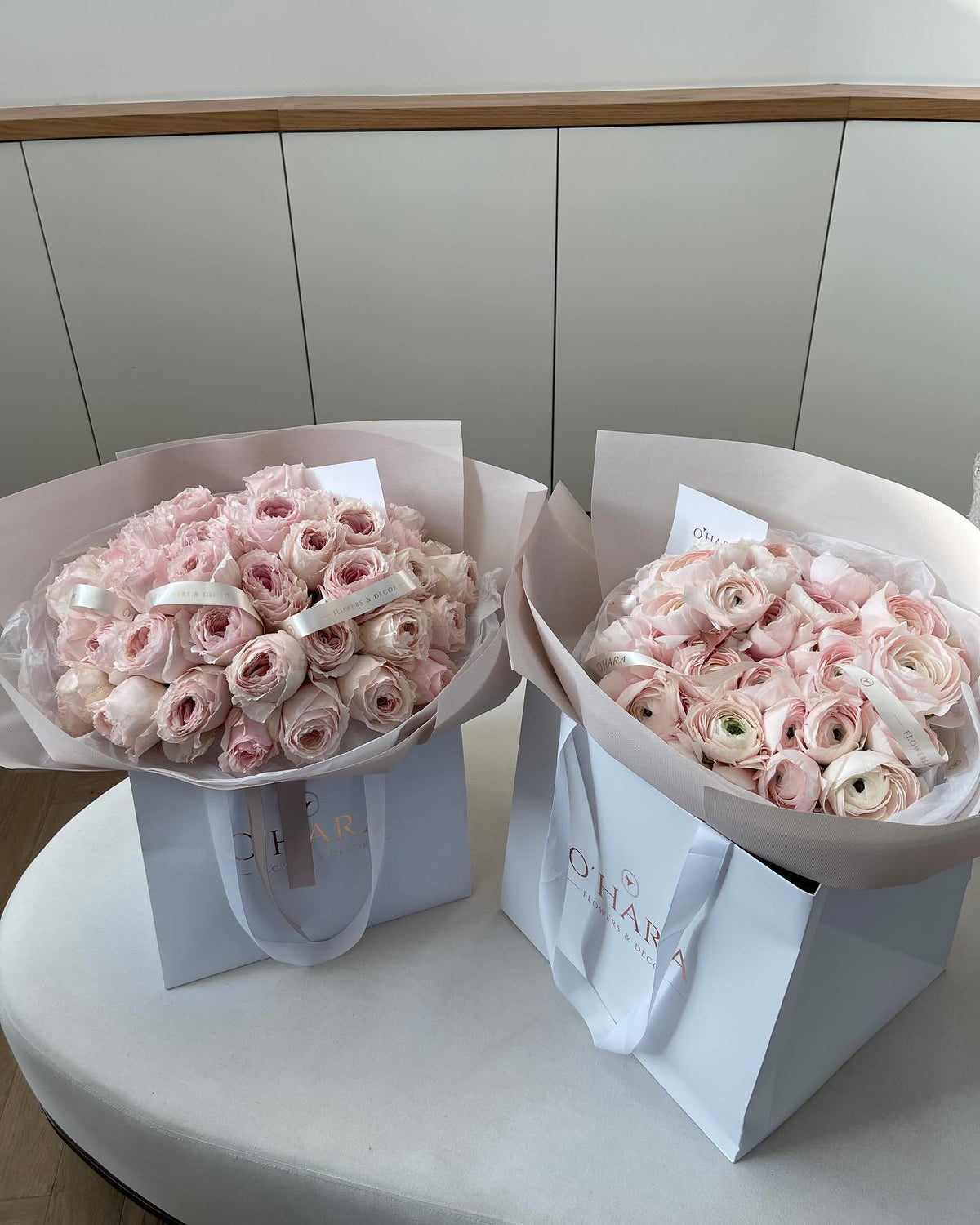 Pink ranunculus bouquets in O'Hara Florist gift bags